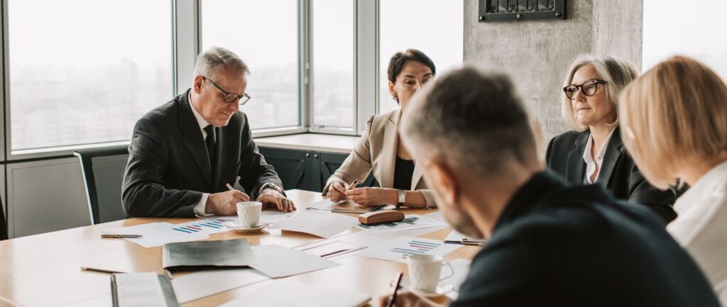 Business professionals engaged in a collaborative meeting around a conference table.